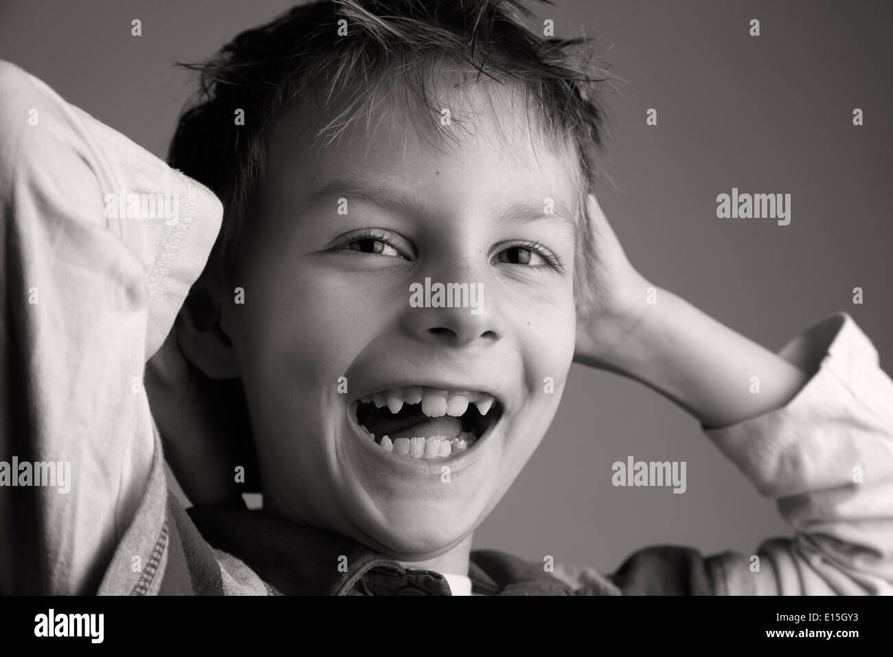 Portrait d'un garçon avec deux lacunes dent rire Banque D'Images