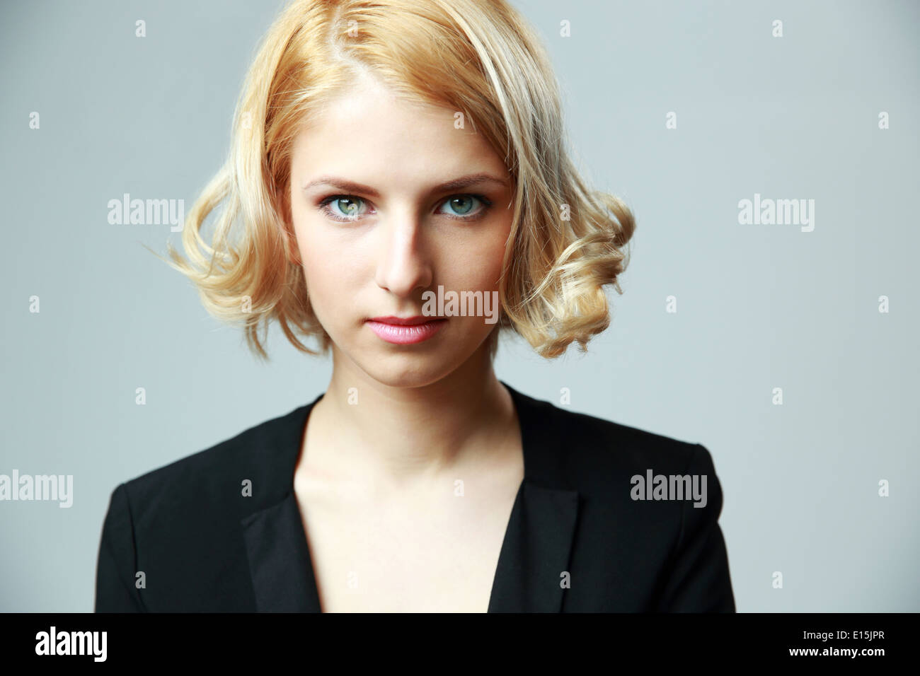 Portrait d'une jeune femme séduisante sur fond gris Banque D'Images