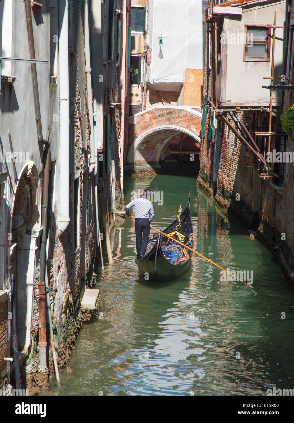 Venise, Italie - 12 mars 2014 : Gondolier sur le petit canal dans le centre de la ville. Banque D'Images