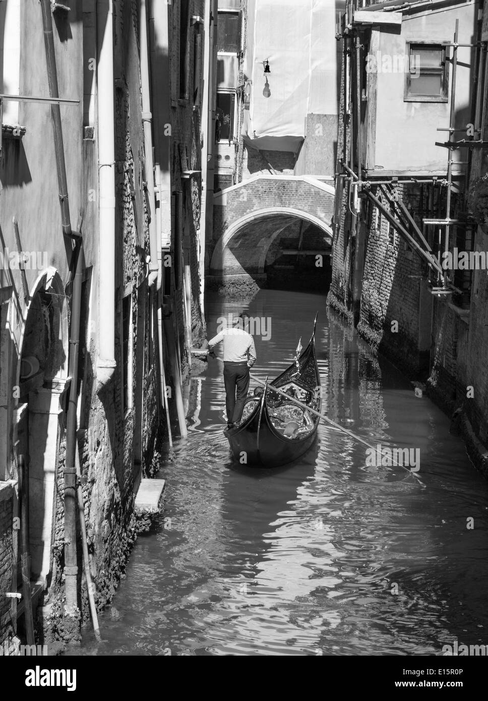 Venise, Italie - 12 mars 2014 : Gondolier sur le petit canal dans le centre de la ville. Banque D'Images