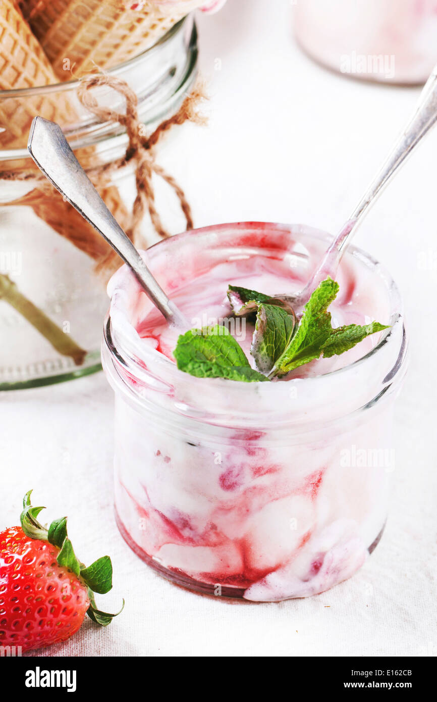 Glace à la fraise à la menthe et les fraises fraîches servi dans un bocal en verre sur textile blanc. Banque D'Images