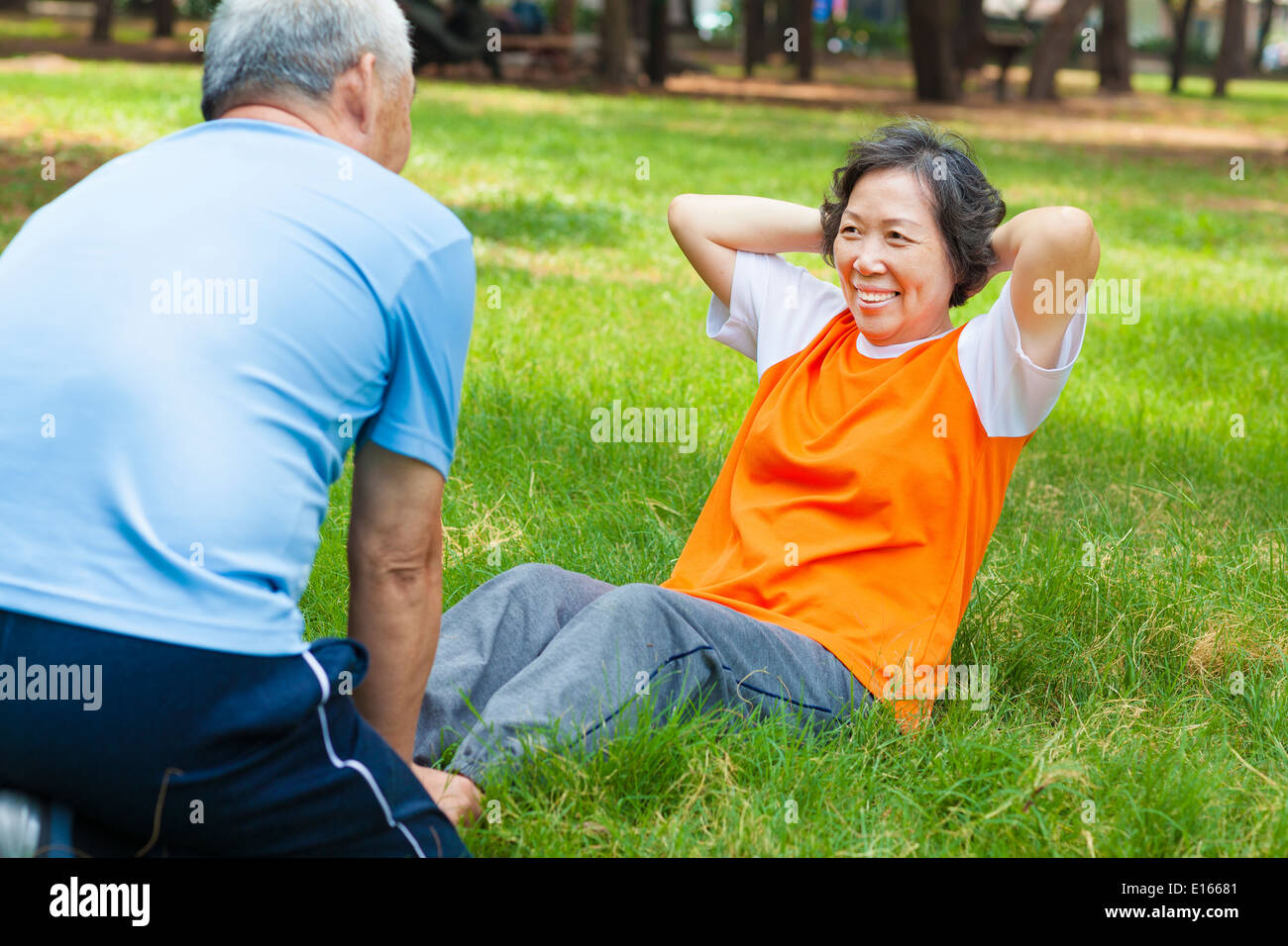 Smiling senior grand-mère faisant reposer-se lève dans le parc Banque D'Images