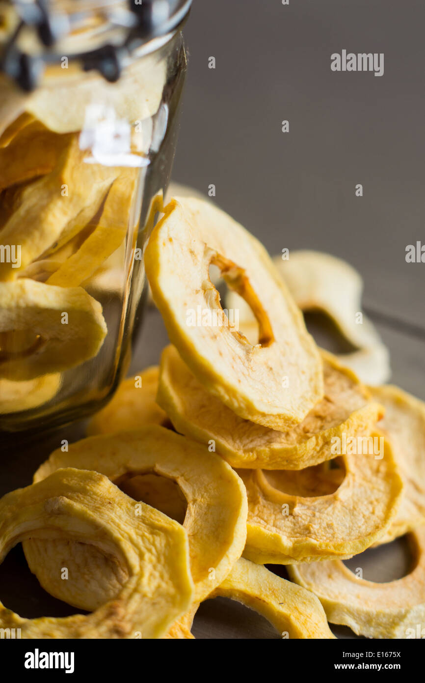 Anneaux de pommes séchées dans un bocal sur la table en bois Banque D'Images