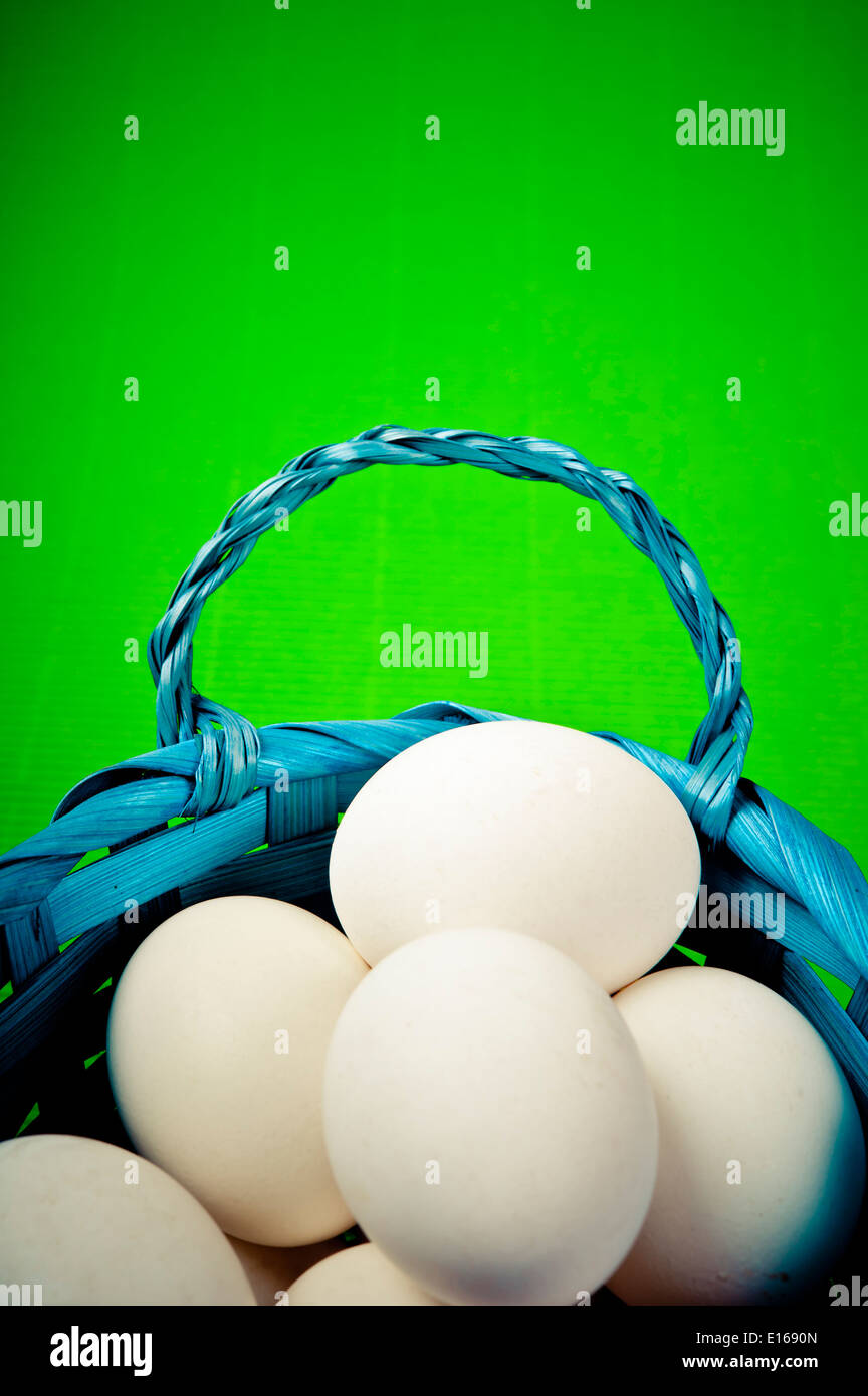 Les œufs blancs dans un panier tissé bleu Banque D'Images