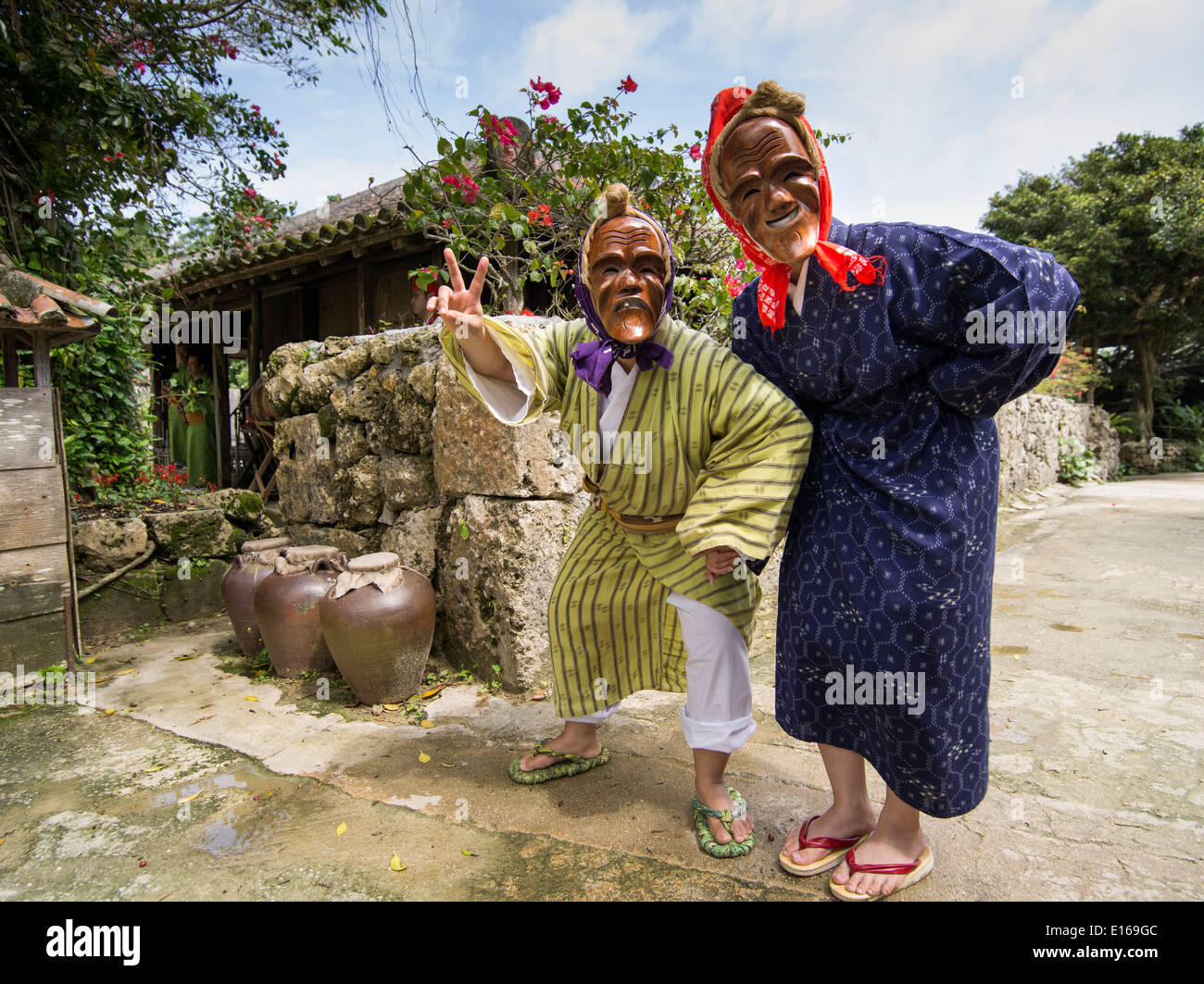 Danseurs portant des masques d'okinawa traditionnel de sourire aux personnes âgées à Ryukyu Mura, Okinawa, Japon Banque D'Images