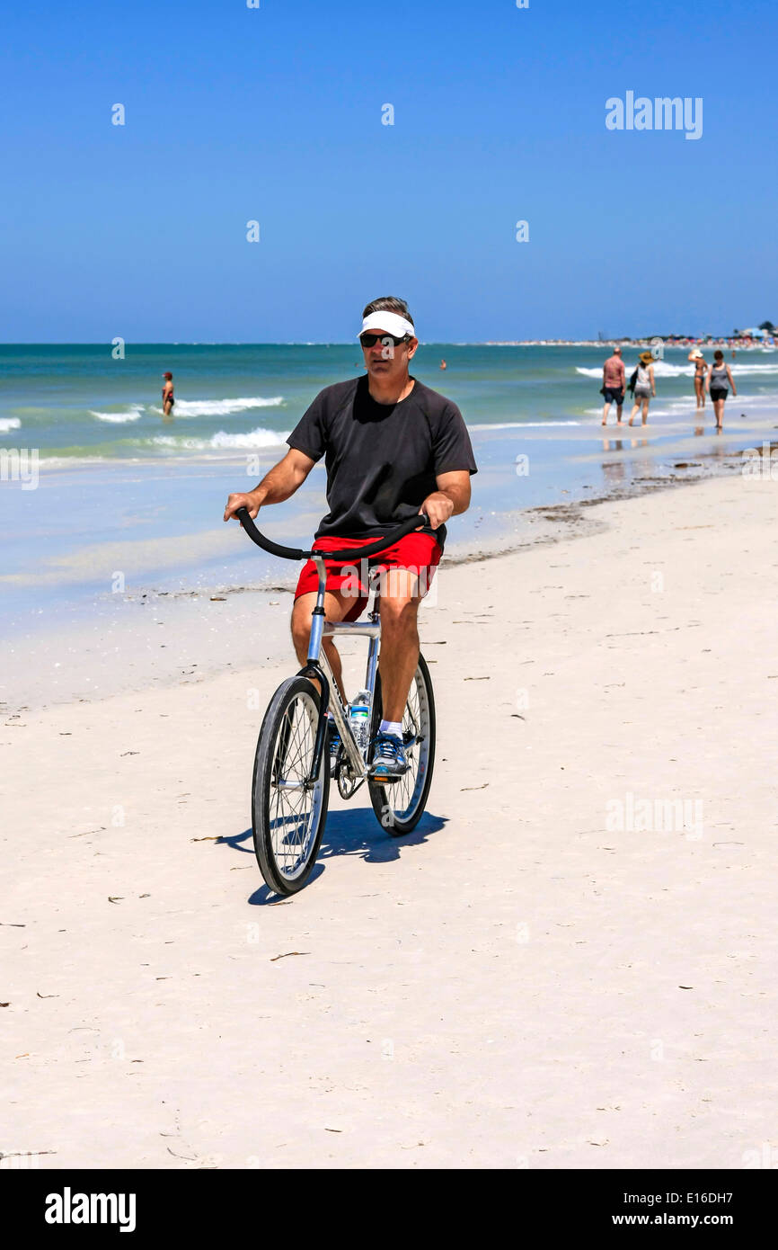 Hot man riding un beach cruiser location sur Siesta Key Beach Florida Banque D'Images