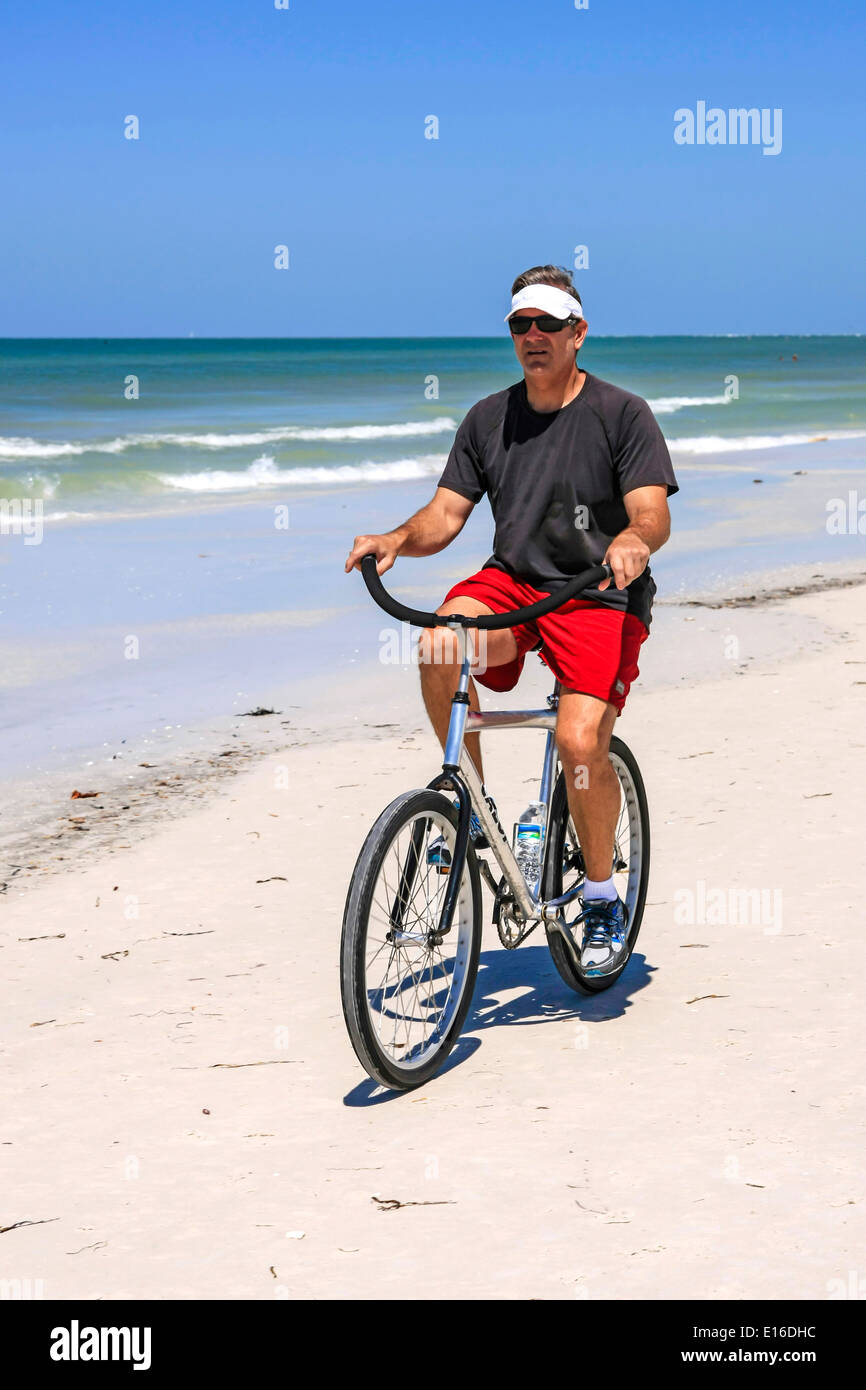 Hot man riding un beach cruiser location sur Siesta Key Beach Florida Banque D'Images