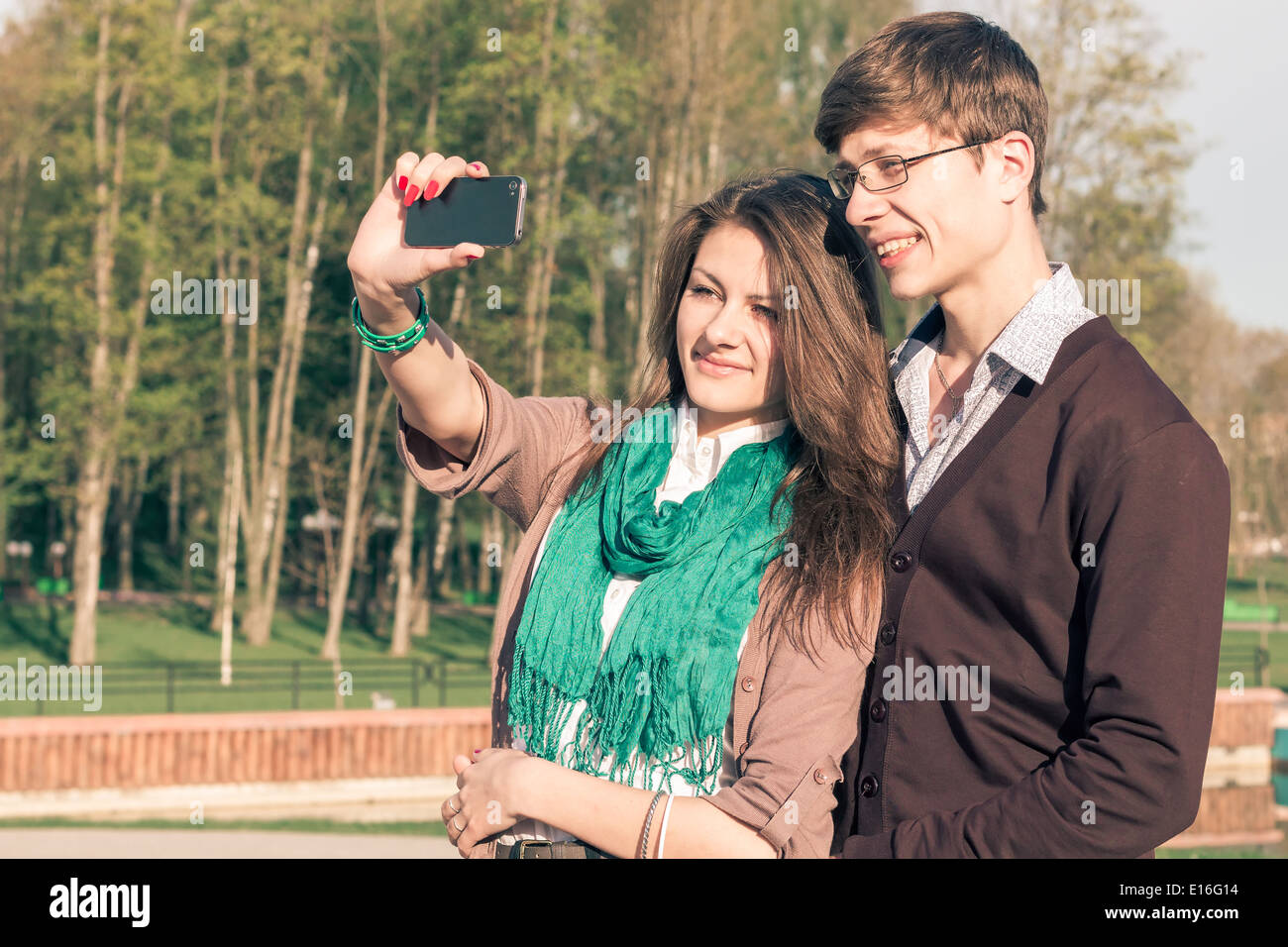 Mode jeune couple élégant élégant selfies prendre un dans un parc. Hipster fille mignonne avec bel homme s'amusant à l'extérieur. Tonique Banque D'Images