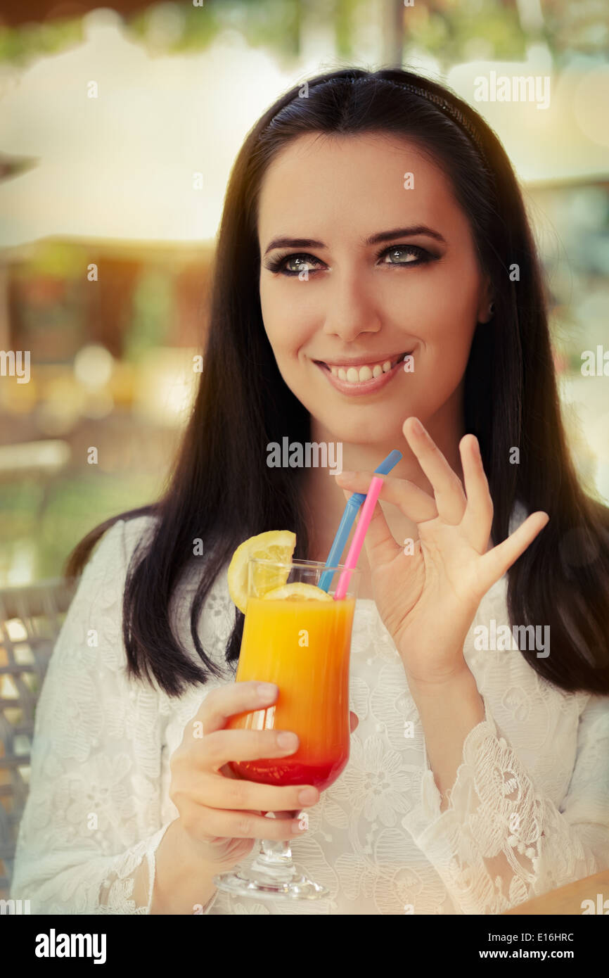 Jeune femme avec cocktail coloré verre dehors Banque D'Images