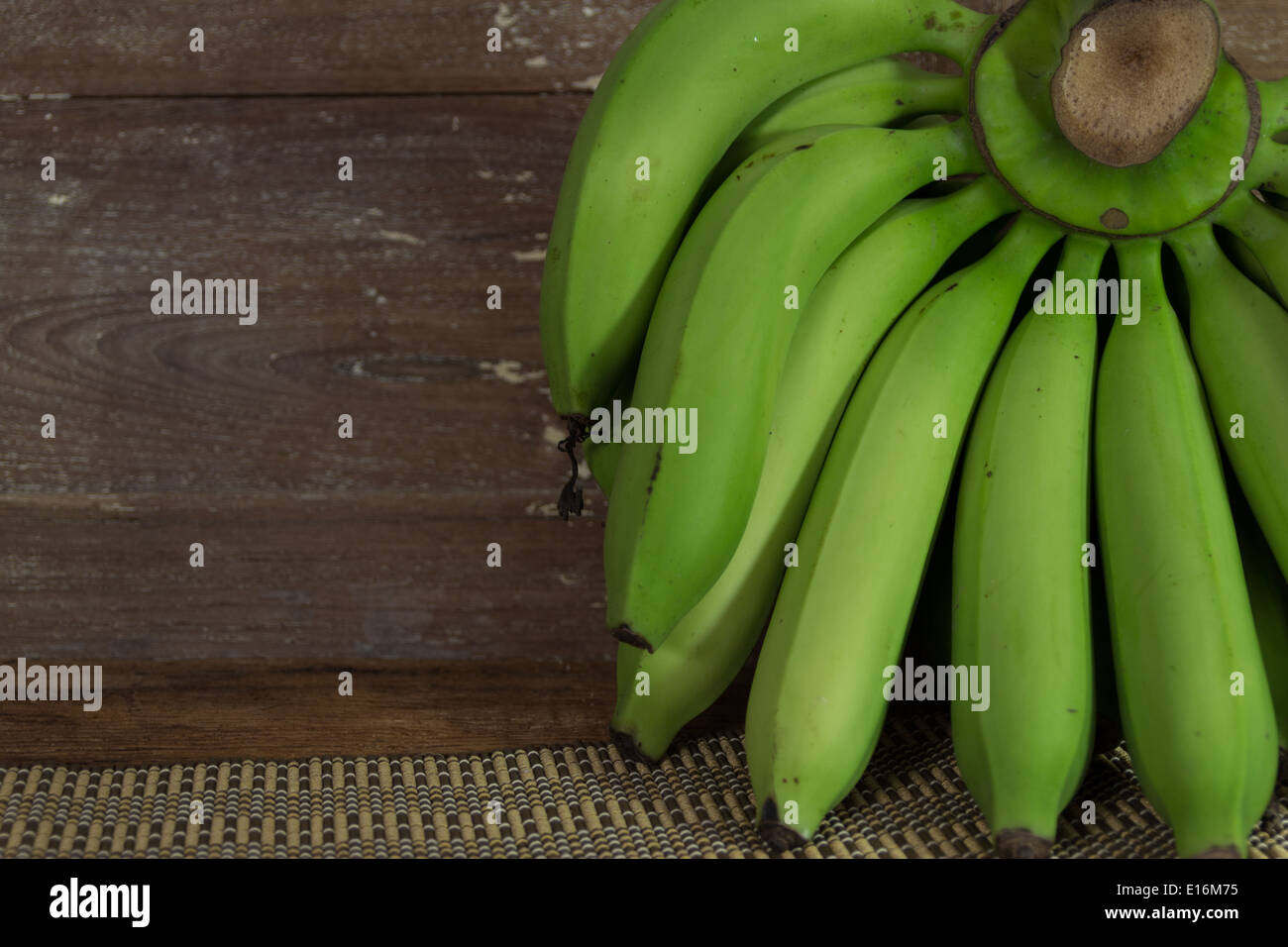 La banane verte sur fond de bois Banque D'Images