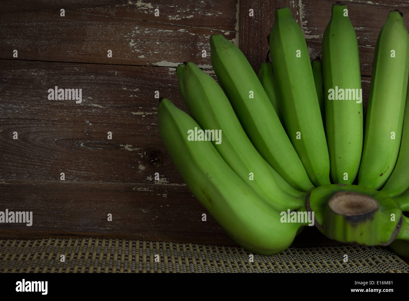 La banane verte sur fond de bois Banque D'Images