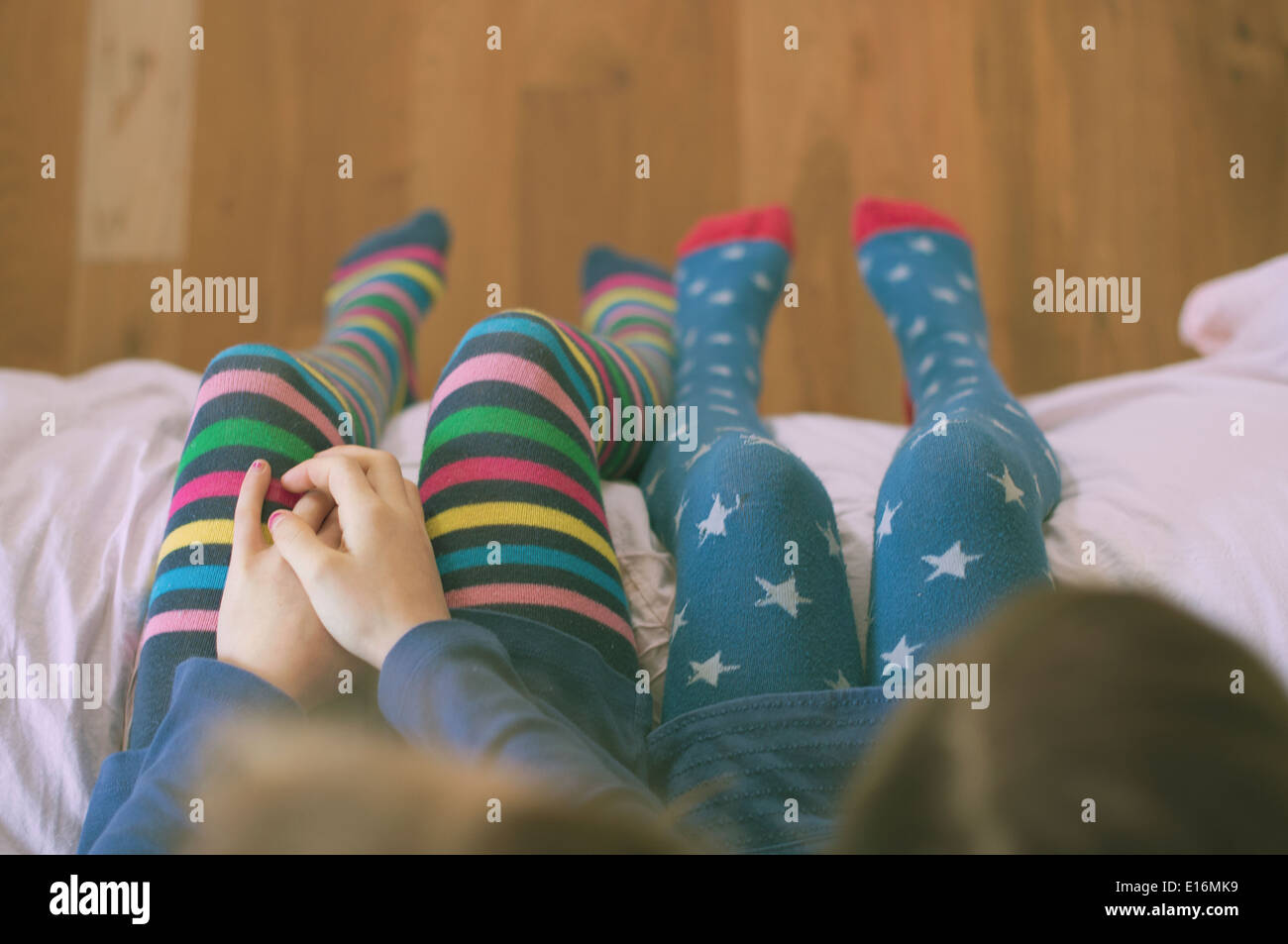 Girls (6-7, 8-9) sitting on bed Banque D'Images