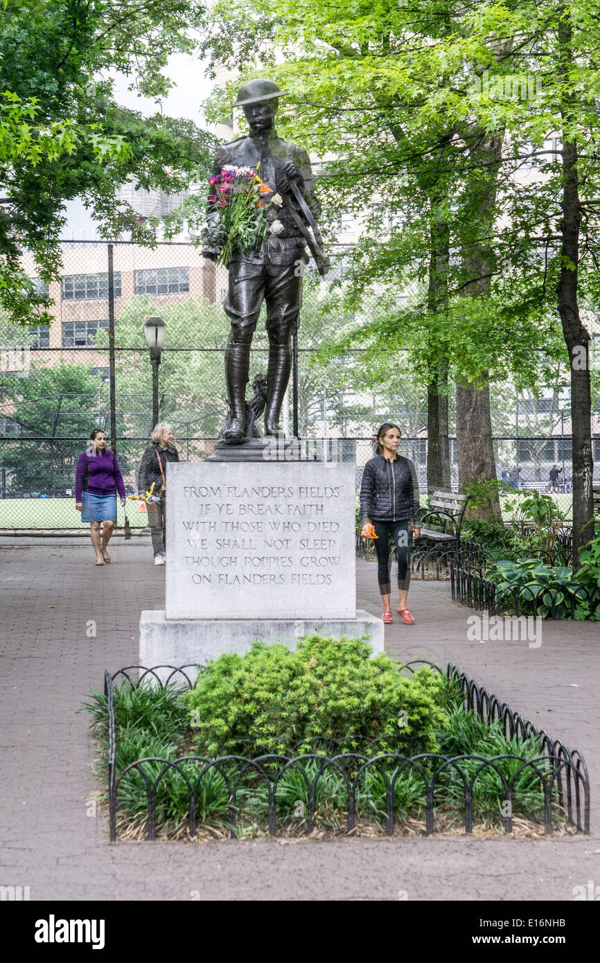 Dewitt Clinton Park, New York City, le 24 mai 2014, USA : WW I bronze doughboy memorial statue dédiée à la cuisine les garçons du voisinage Hells qui sont morts dans la PREMIÈRE GUERRE MONDIALE, détient un hommage anonyme de frais colorés de fleurs de printemps le premier jour du Memorial Day 3 Jour week-end de vacances Banque D'Images
