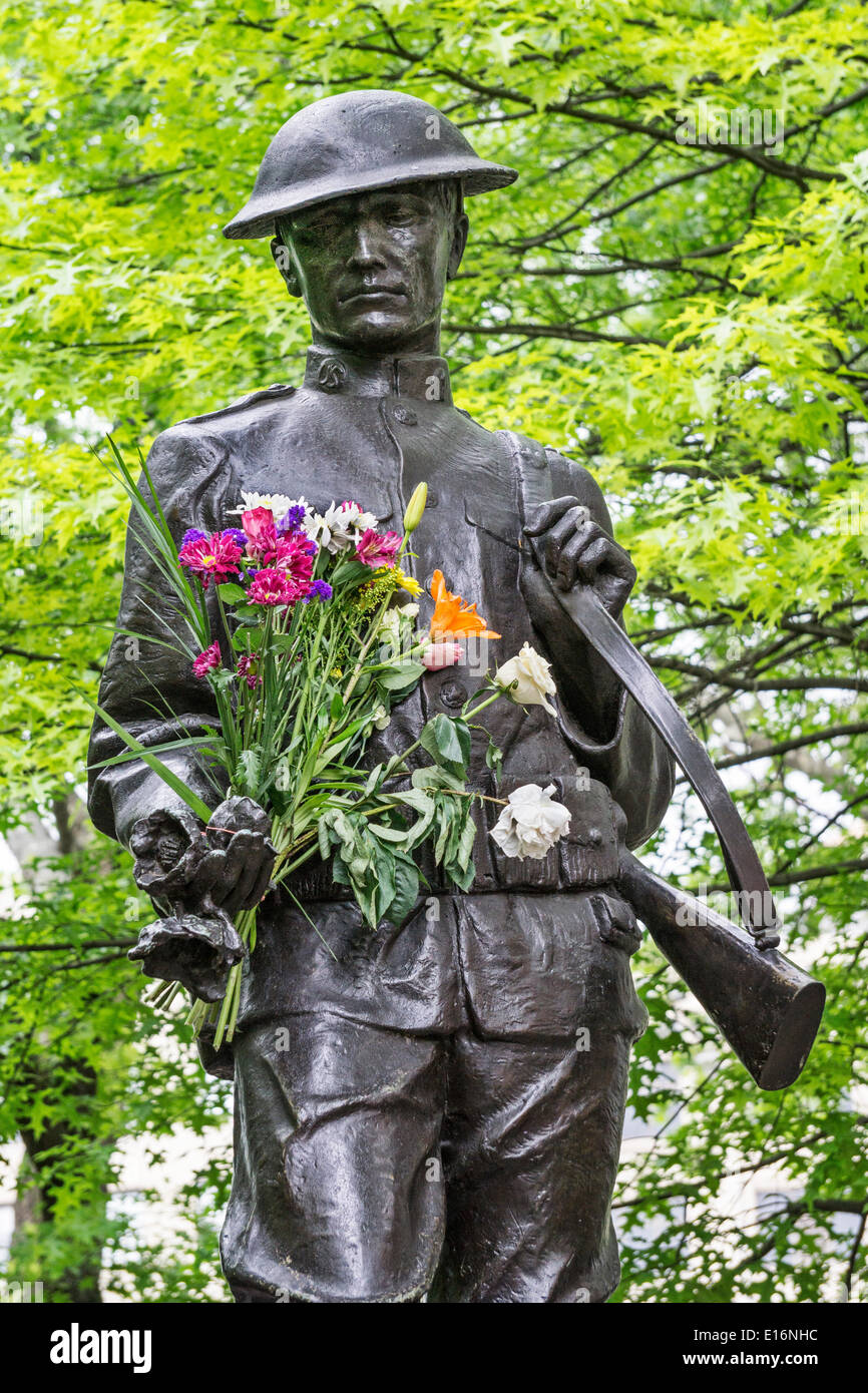 Dewitt Clinton Park, New York City, le 24 mai 2014, USA : WW I bronze doughboy memorial statue dédiée à la cuisine les garçons du voisinage Hells qui sont morts dans la PREMIÈRE GUERRE MONDIALE, détient un hommage anonyme de frais colorés de fleurs de printemps le premier jour du Memorial Day 3 Jour week-end de vacances Banque D'Images