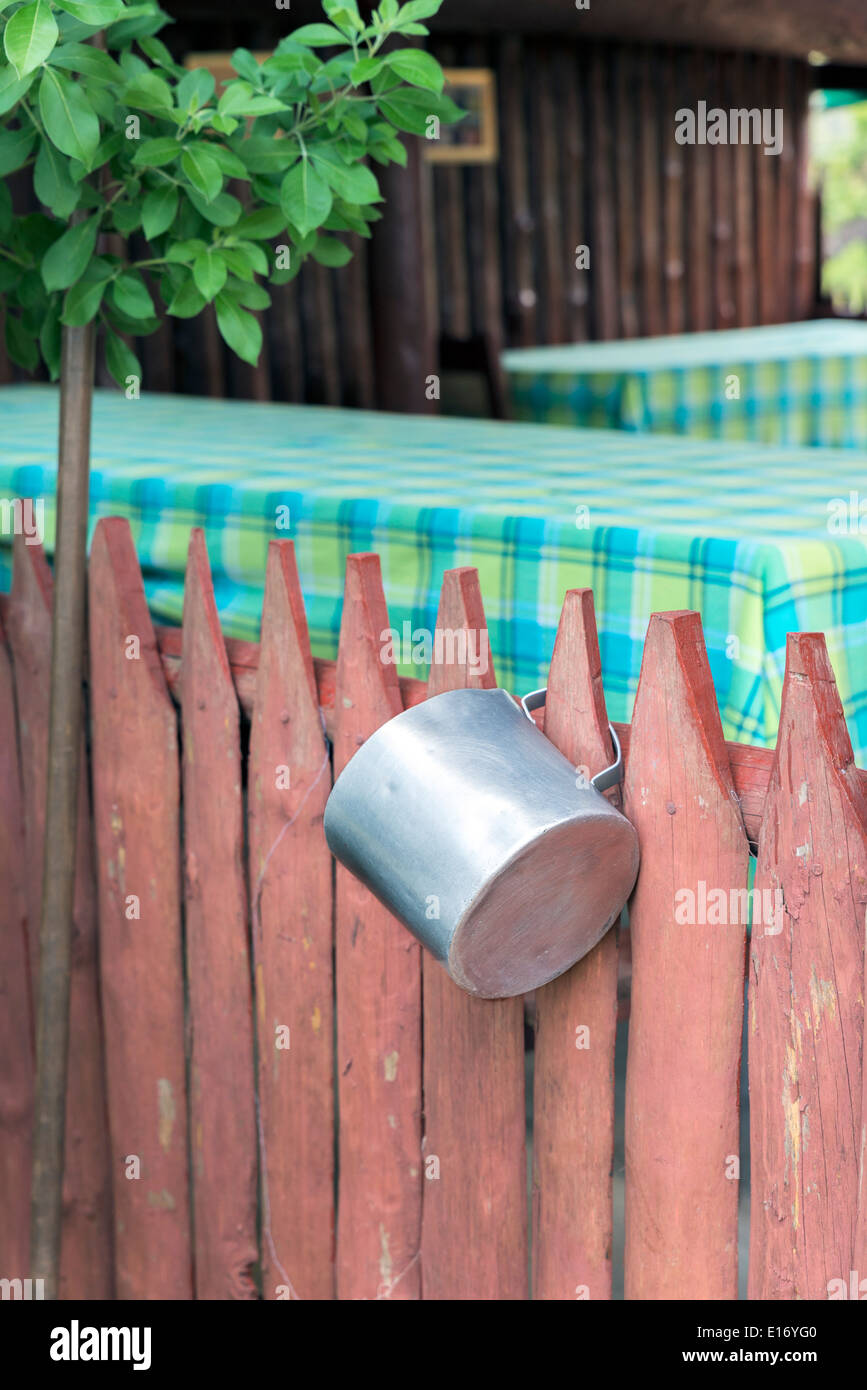 Casserole en aluminium accroché à une clôture en bois Banque D'Images