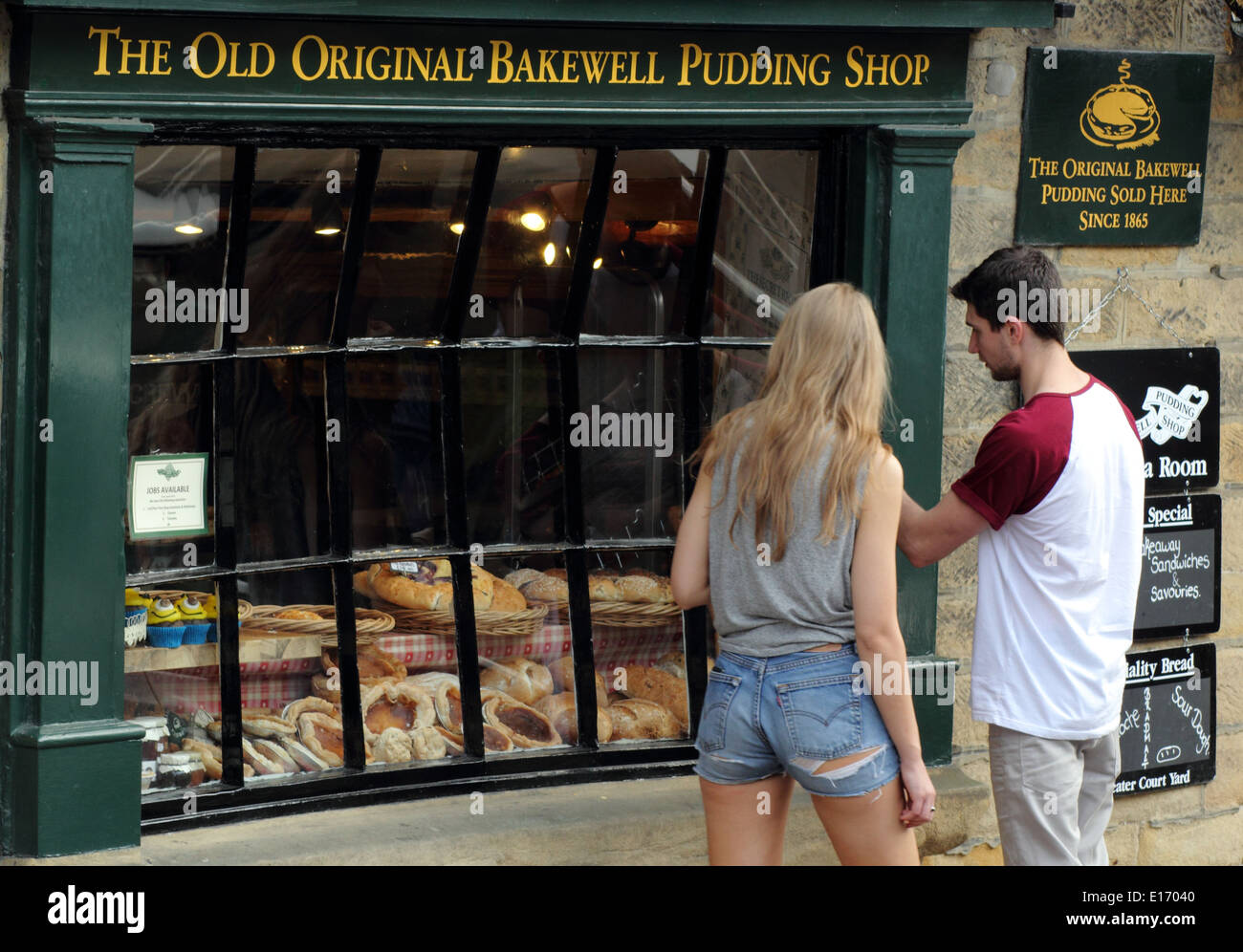 Pause touristes à regarder dans l'ancienne boutique de pudding Bakewell original de Bakewell, Peak District, England, UK Banque D'Images