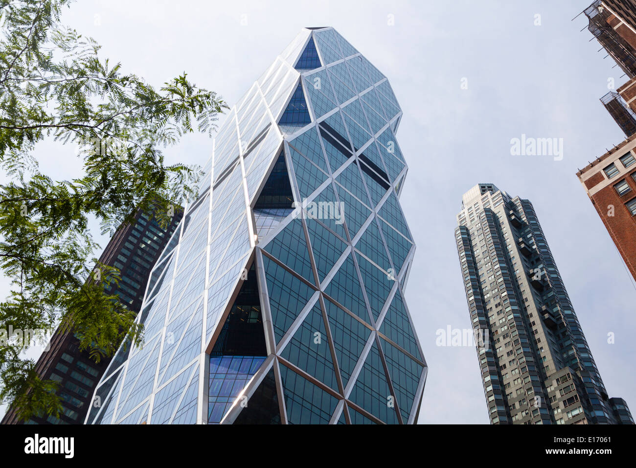 La Hearst Tower à New York, entre autres gratte-ciel avec ciel bleu Banque D'Images