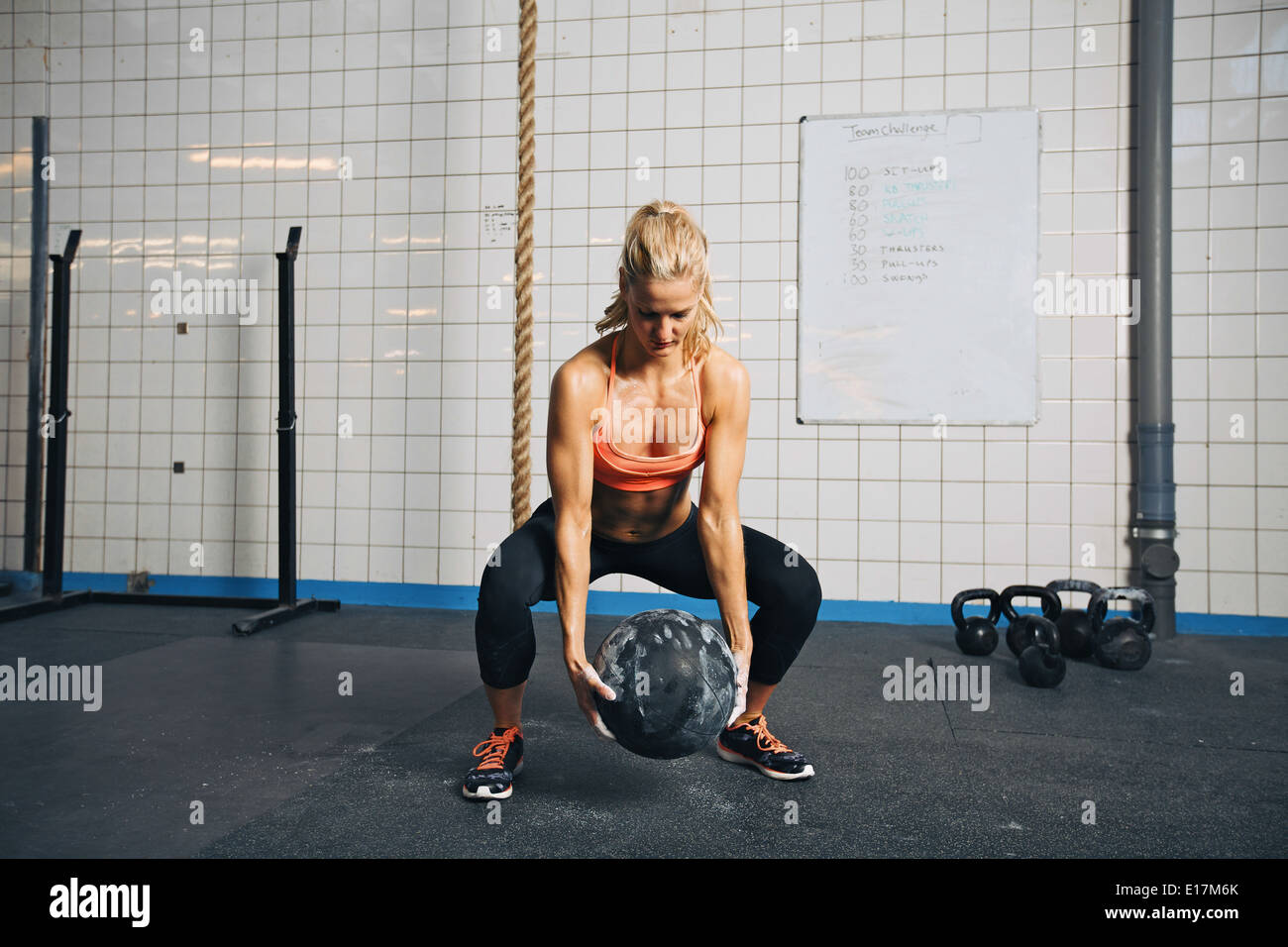 Mettre en place et de l'athlète féminine forte l'élaboration avec un ballon pour obtenir une meilleure force de base et la stabilité. Woman doing exercise. Banque D'Images