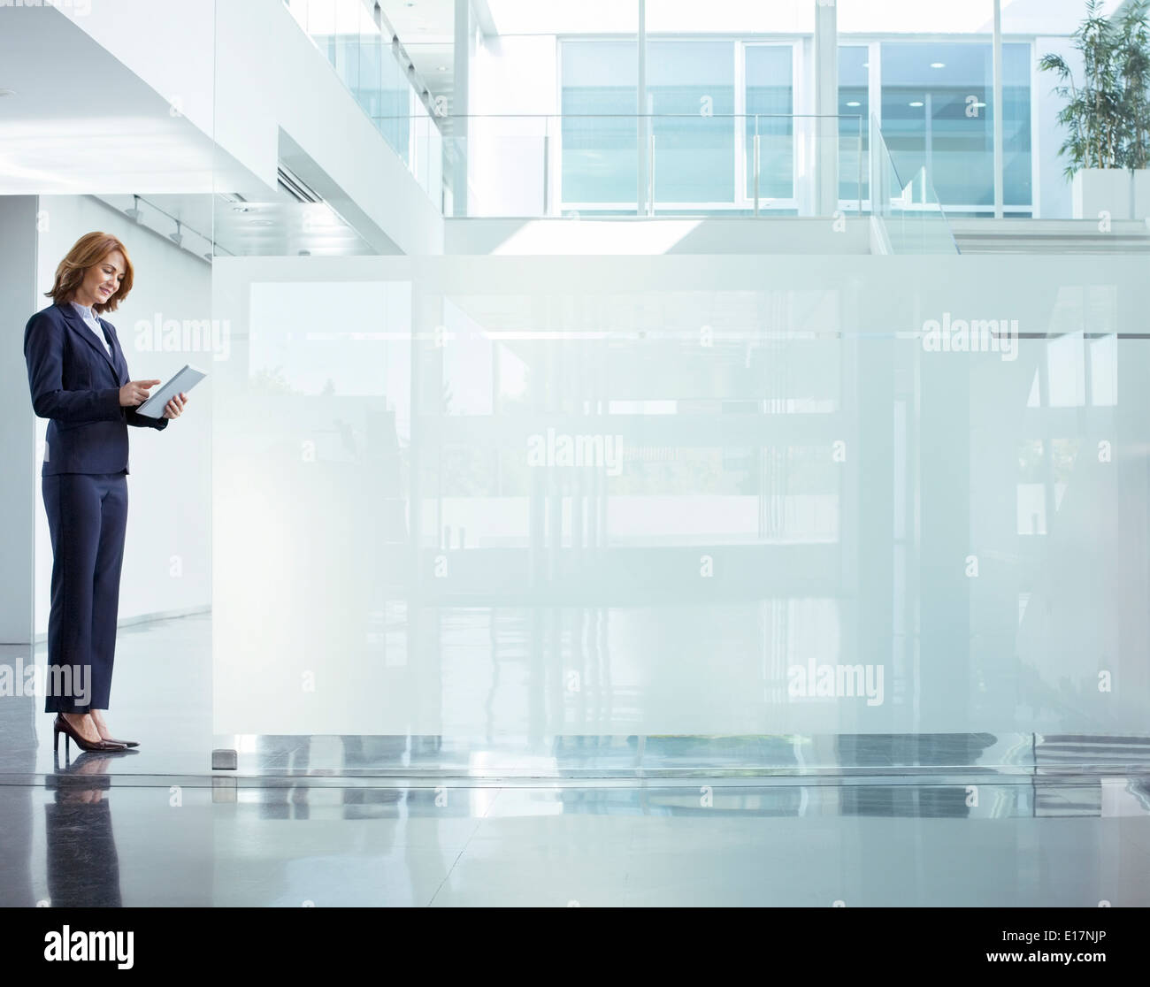 Businesswoman using digital tablet in office lobby Banque D'Images
