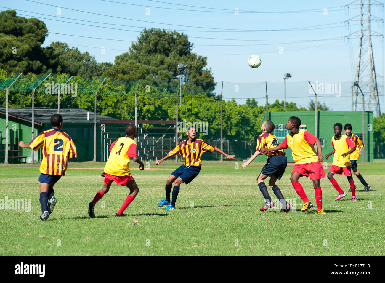 Joueurs de football junior suivre la boule volant par l'air, Le Cap, Afrique du Sud Banque D'Images