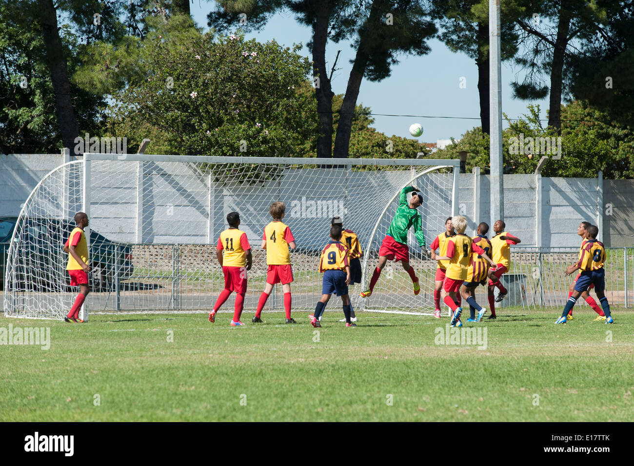 Gardien sautant en l'air d'autres joueurs de football de suivre la boule, Cape Town, Afrique du Sud Banque D'Images