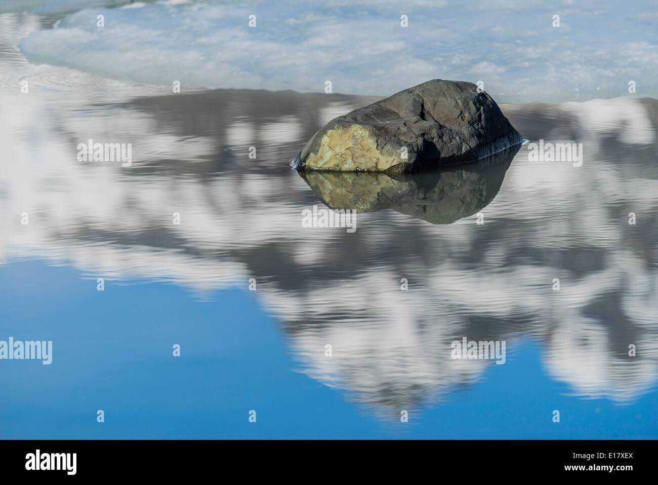 Rock avec sky reflète dans l'eau, Fjallsarlon Glacial Lagoon, Iceland Banque D'Images