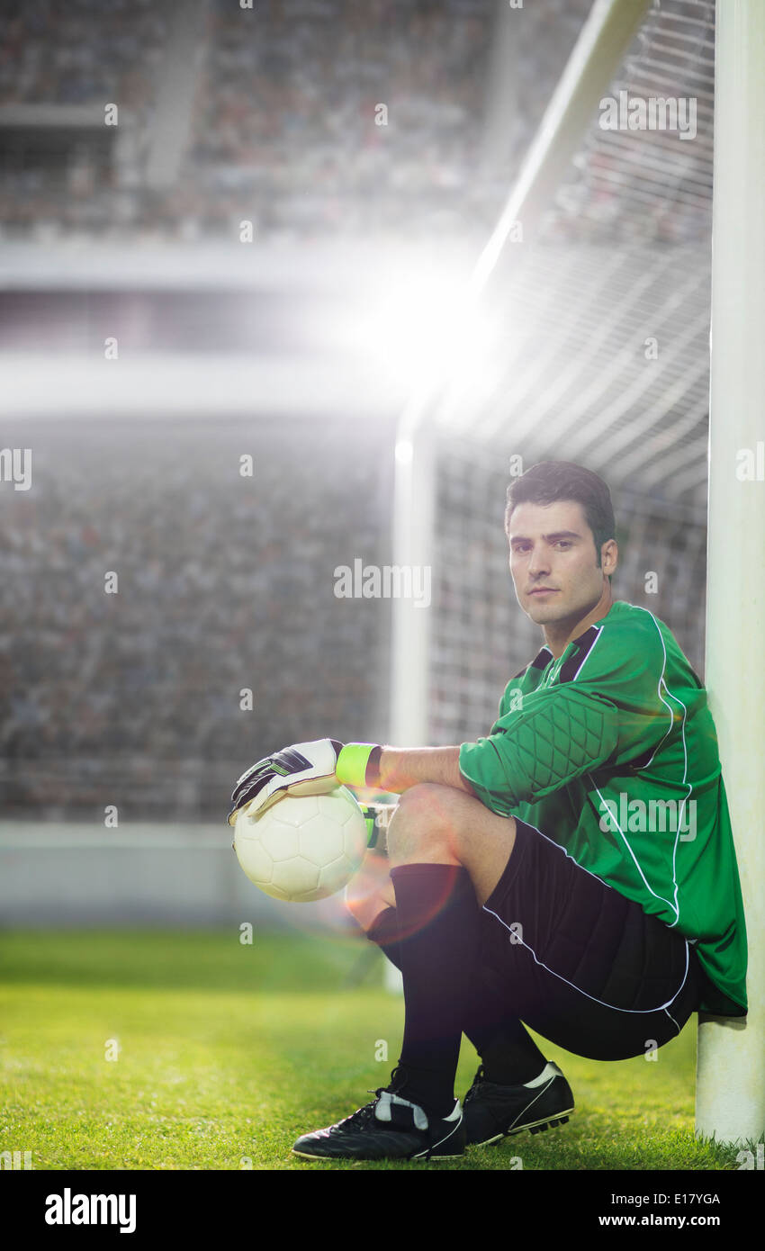 Gardien holding soccer ball par net Banque D'Images