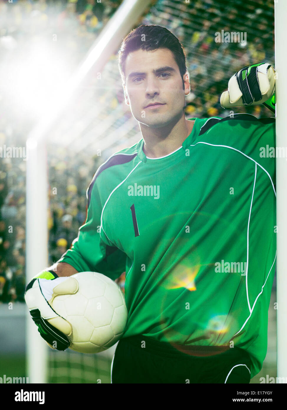 Gardien holding soccer ball dans net Banque D'Images