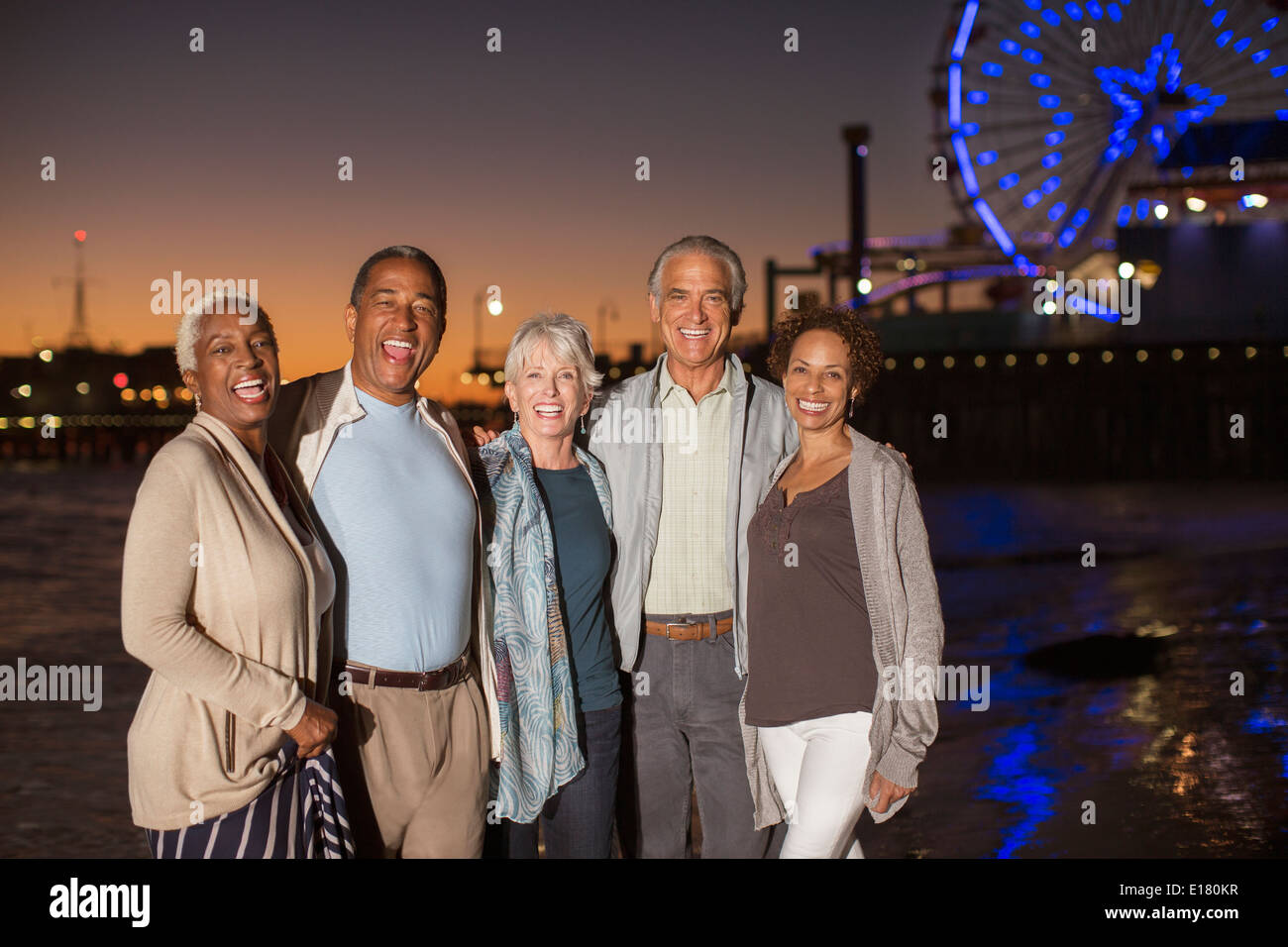 Portrait of senior friends on beach at night Banque D'Images