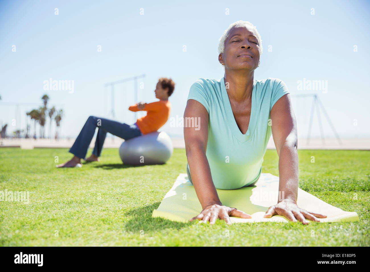 Les femmes pratiquant le yoga à sunny park Banque D'Images