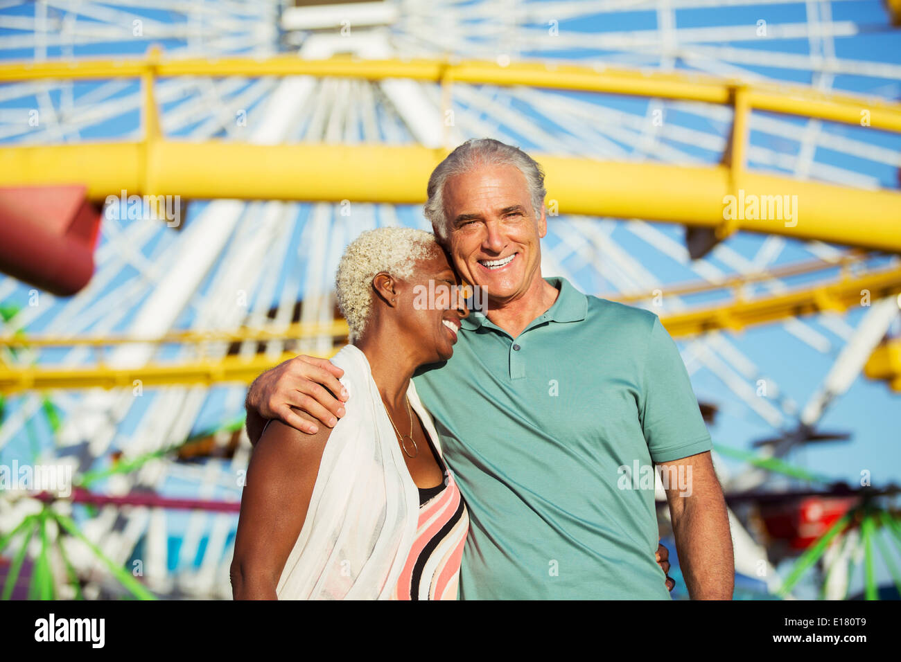 Portrait de senior couple hugging at amusement park Banque D'Images