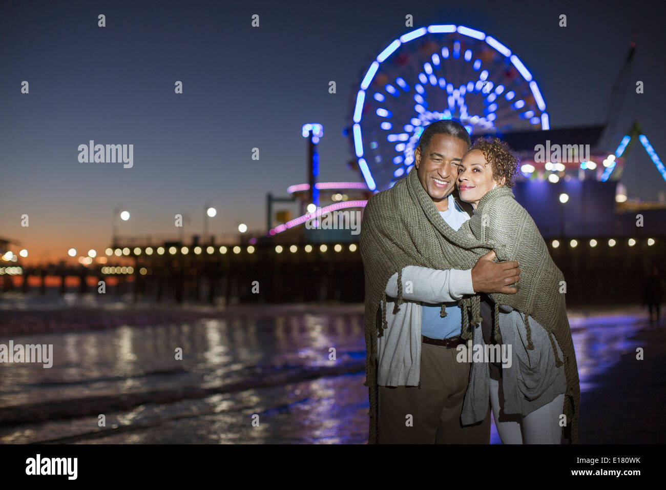 Couple hugging on beach at night Banque D'Images