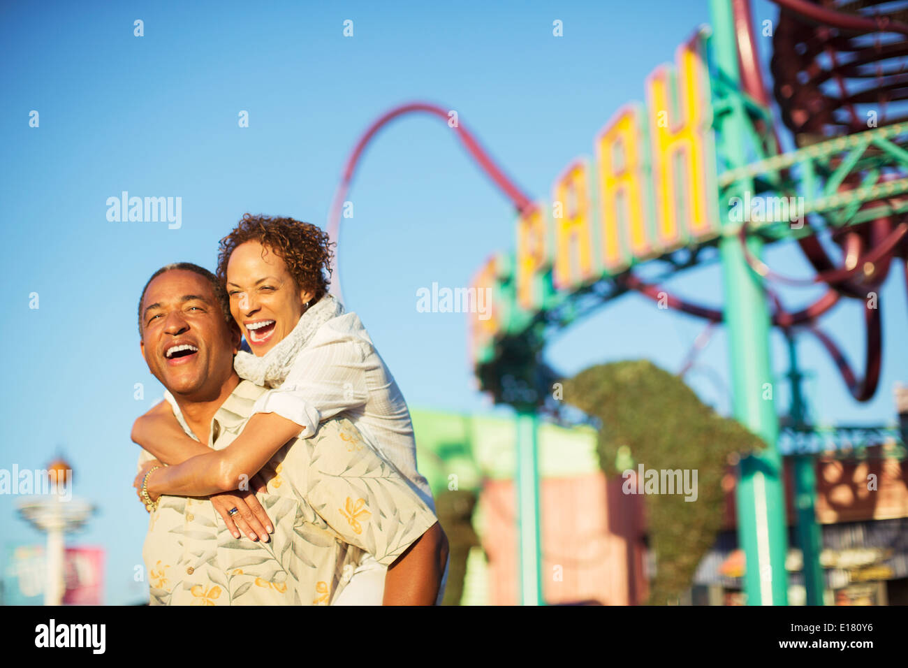 Enthousiaste couple hugging at amusement park Banque D'Images