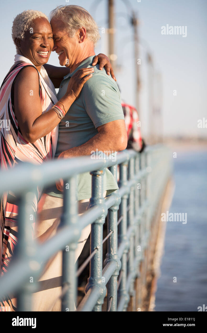 Senior couple hugging on pier Banque D'Images