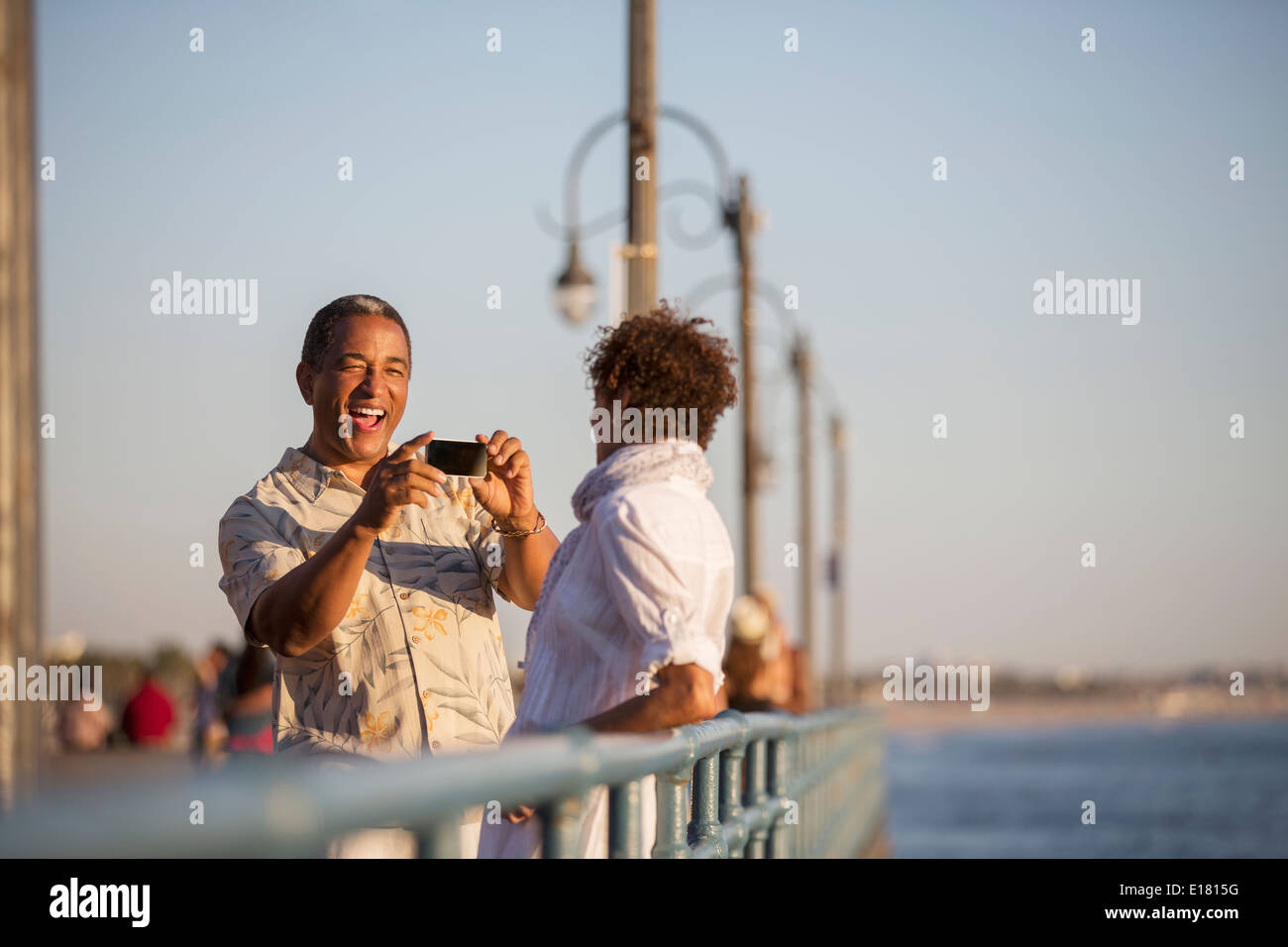 Man photographing woman on pier Banque D'Images