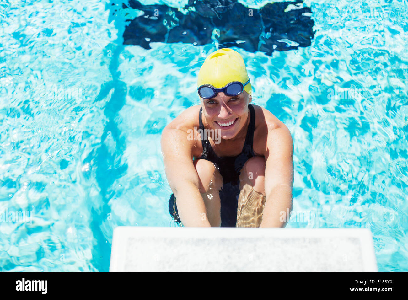 Portrait of smiling swimmer au bloc de départ Banque D'Images
