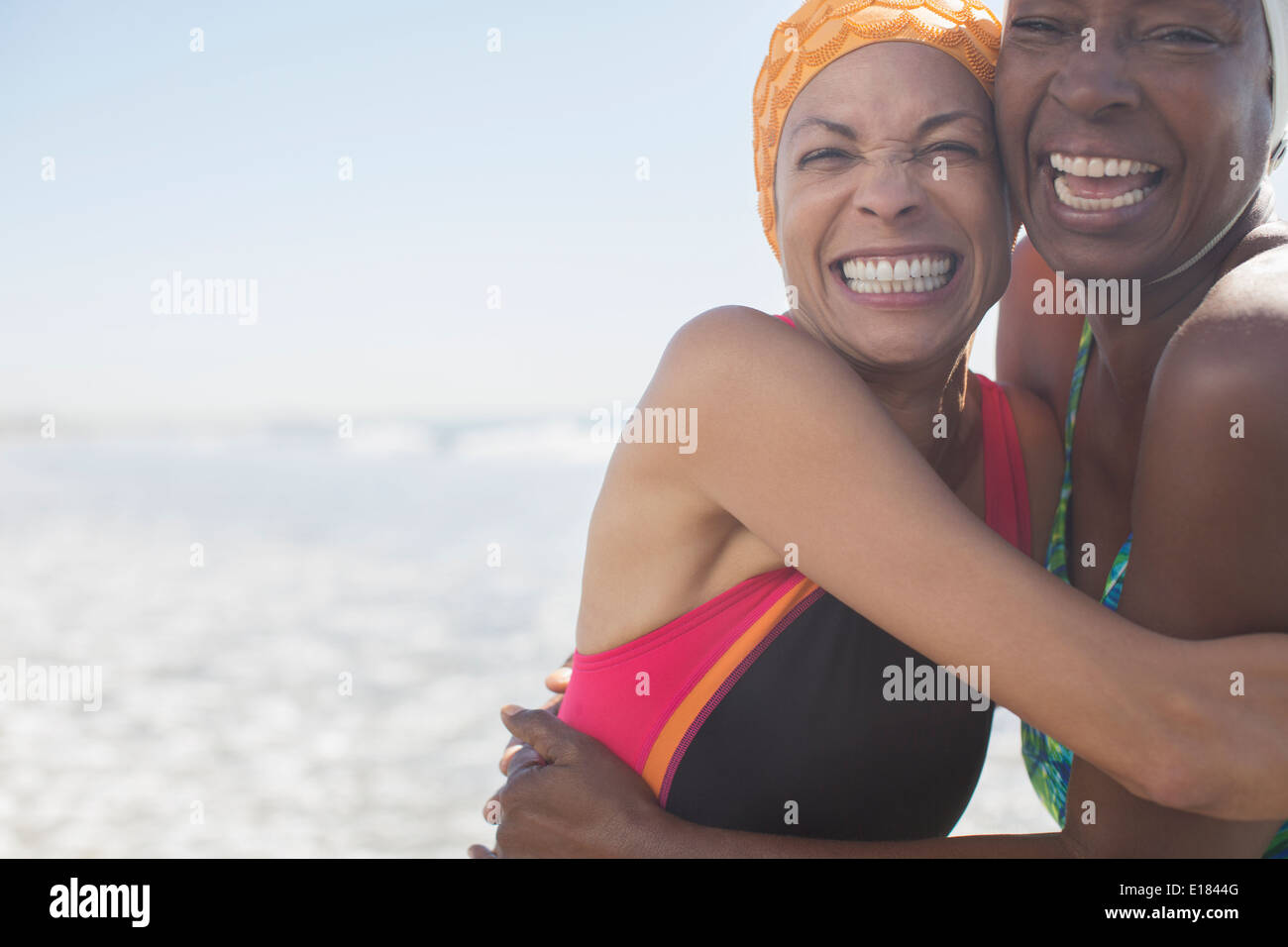 Les femmes enthousiastes hugging on beach Banque D'Images
