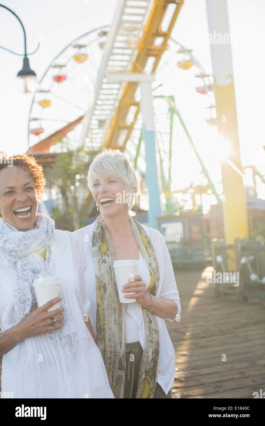 Les femmes âgées de rire et de boire du café à amusement park Banque D'Images