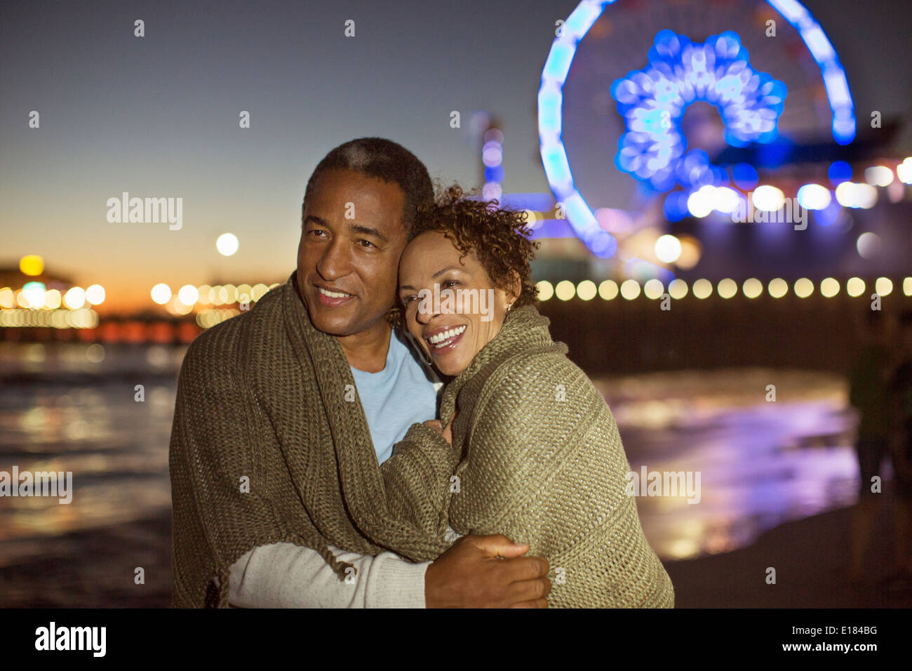 Couple hugging on beach at night Banque D'Images