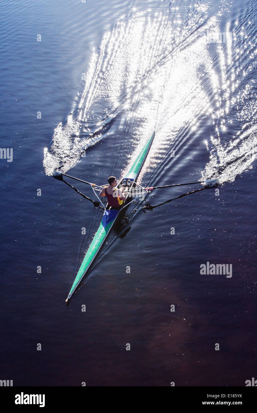 Man rowing scull on lake Banque D'Images