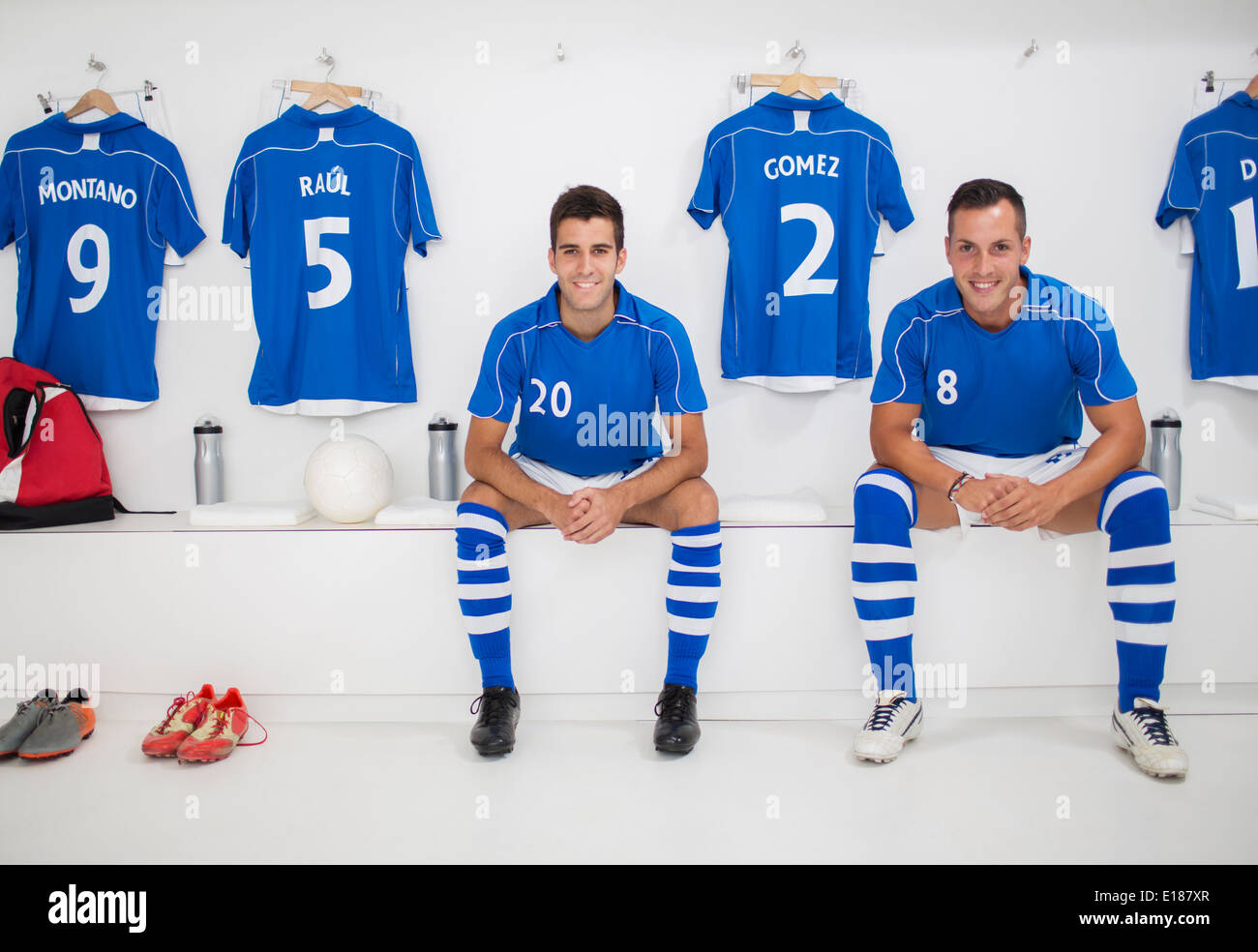 Joueurs de football smiling in locker room Banque D'Images