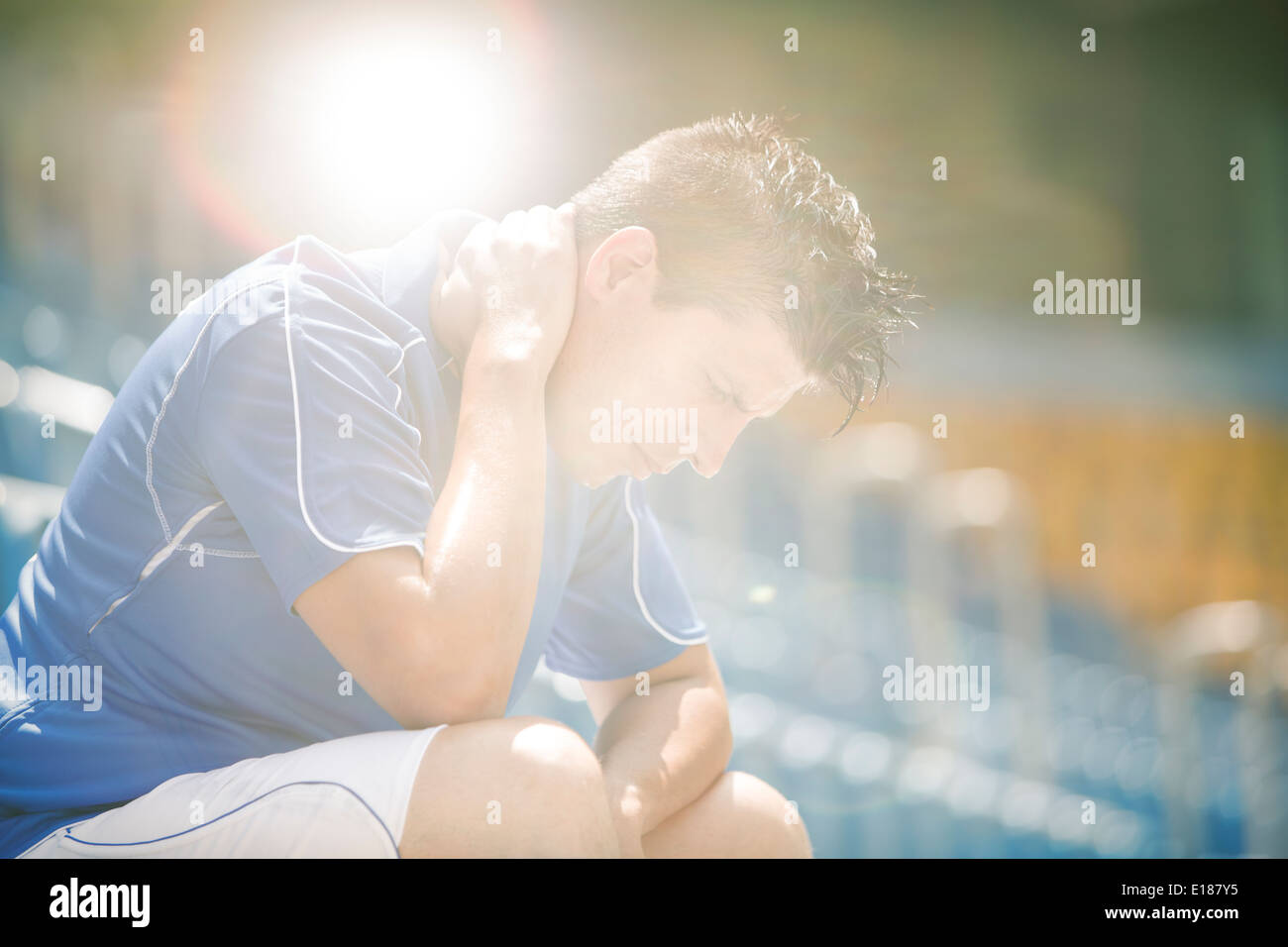 Déçu soccer player sitting in stadium Banque D'Images