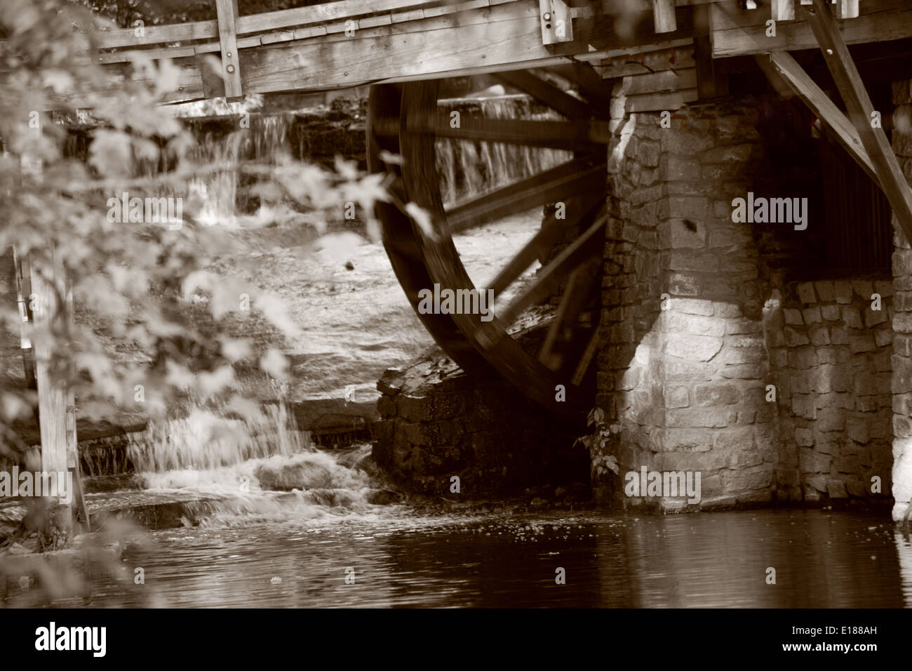 Grist mill faites de vieux bois patiné et avec l'ancienne roue de l'eau, à l'automne de l'année en sépia Banque D'Images