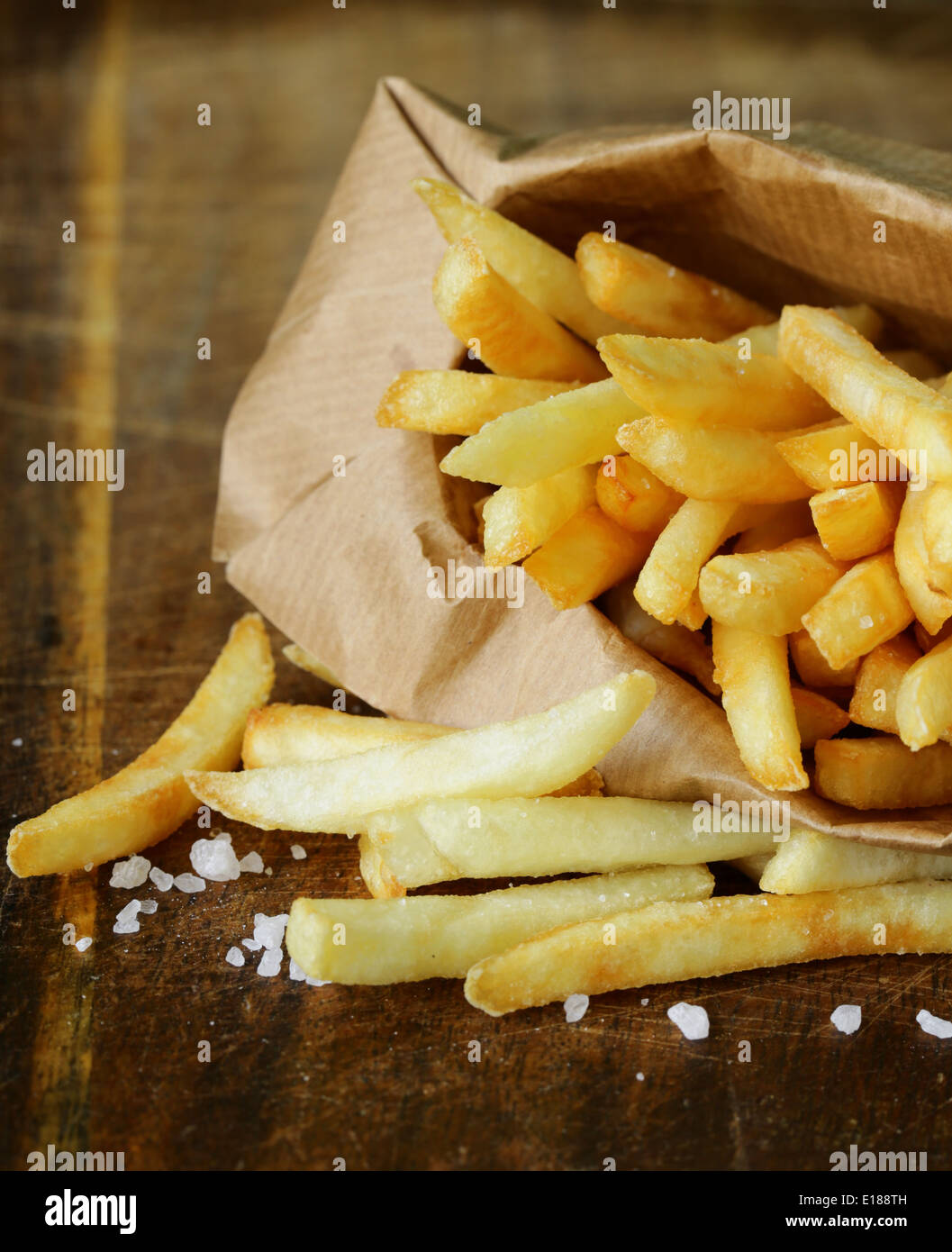 Pommes frites traditionnelles avec du sel sur fond de bois Banque D'Images