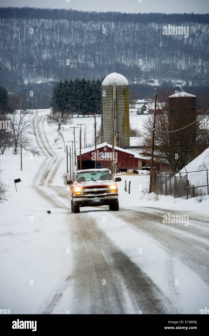 Pick up truck rouge de la conduite sur route de campagne et l'hiver avec des projecteurs. L'ouest du Maryland Banque D'Images