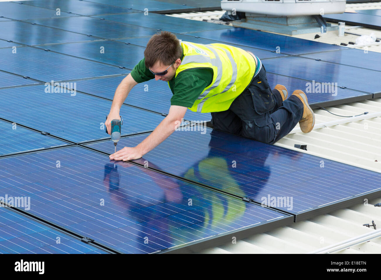 Les panneaux solaires photovoltaïques en cours d'installation sur un toit Banque D'Images