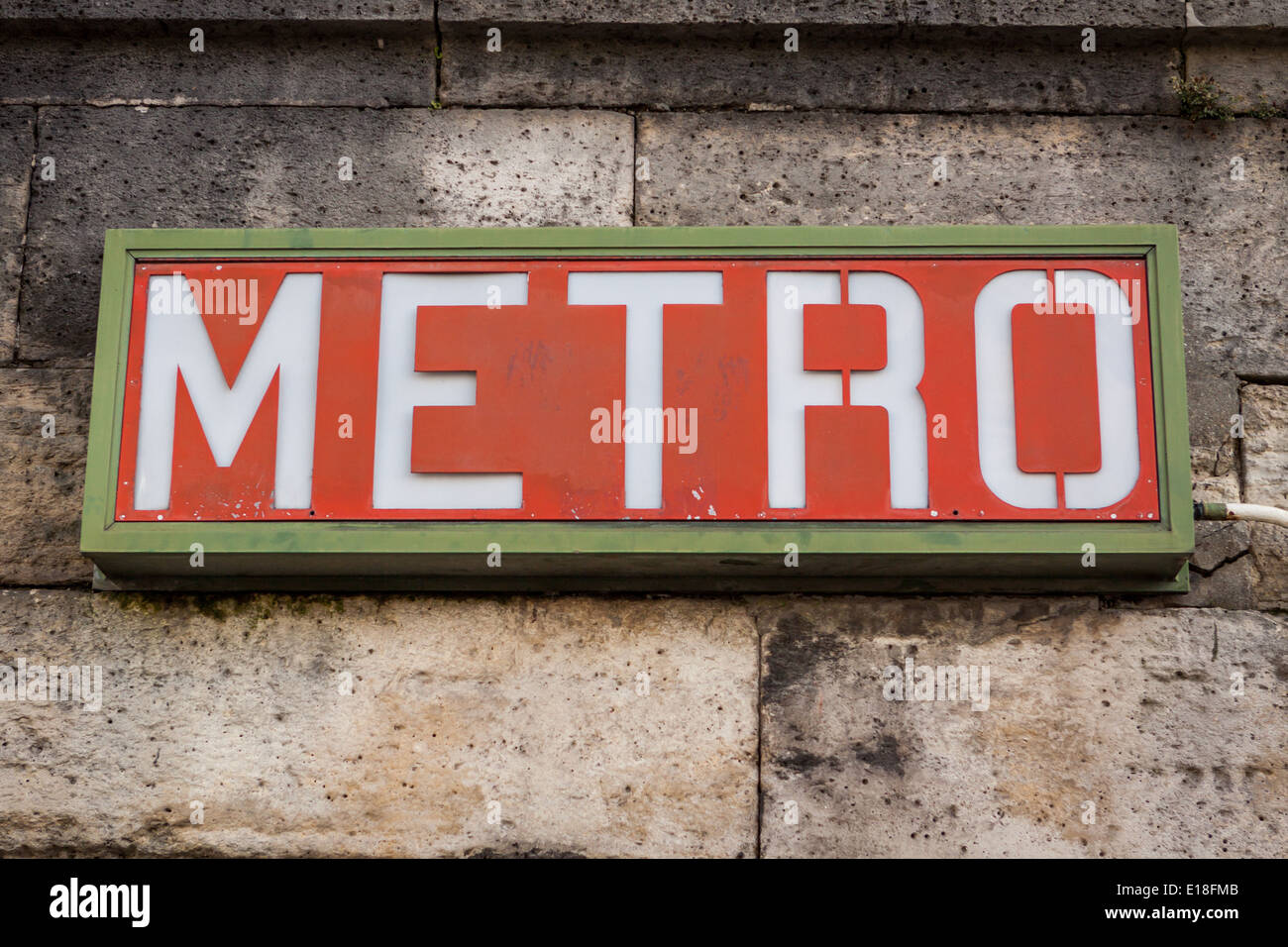 Paris Métro rouge signe sur un mur de pierre pour la fréquence élevée du système ferroviaire souterrain urbain Banque D'Images