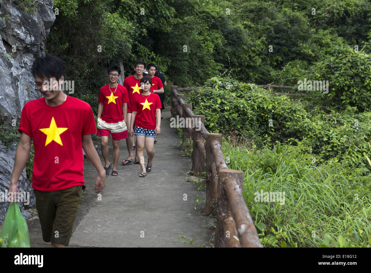 Un groupe de jeunes à pied autour de l'île de Cat Ba vêtus de T-shirts avec le drapeau du Vietnam Banque D'Images
