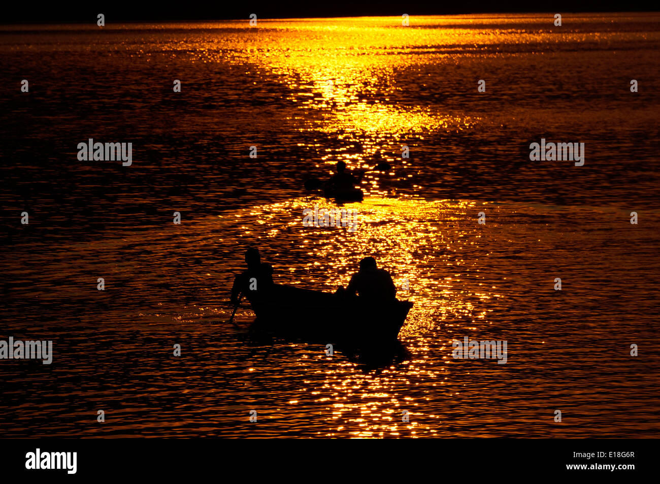 Bateau de pêche au coucher du soleil la réflexion. Banque D'Images