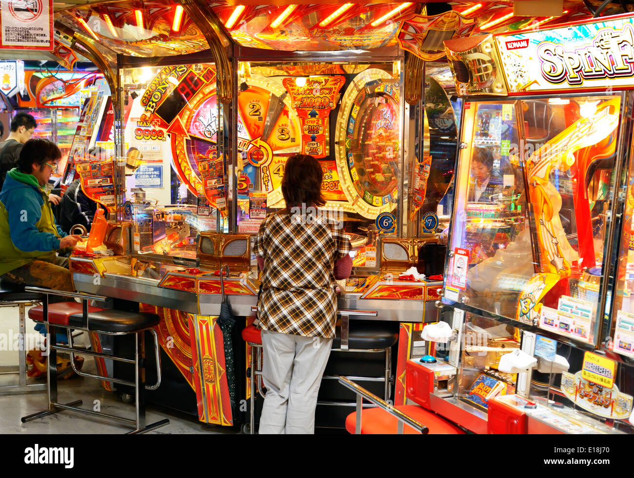 Les gens à jouer à un jeu d'arcade à Tokyo, Japon. Banque D'Images